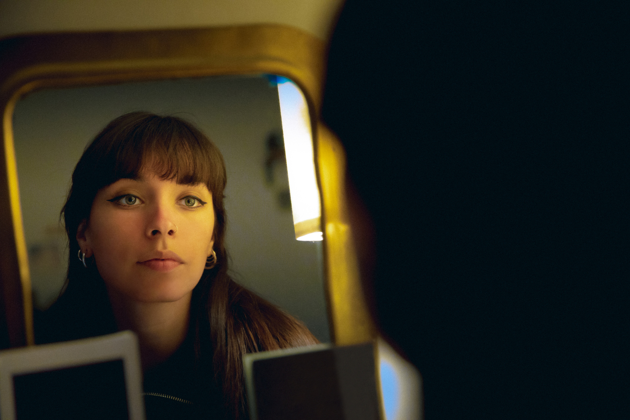young beautiful woman looking in the mirror