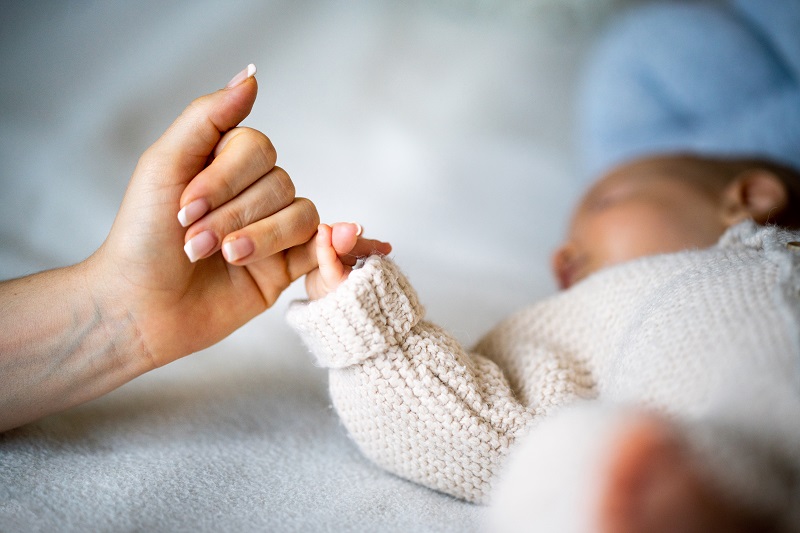 New mom holding baby's hand