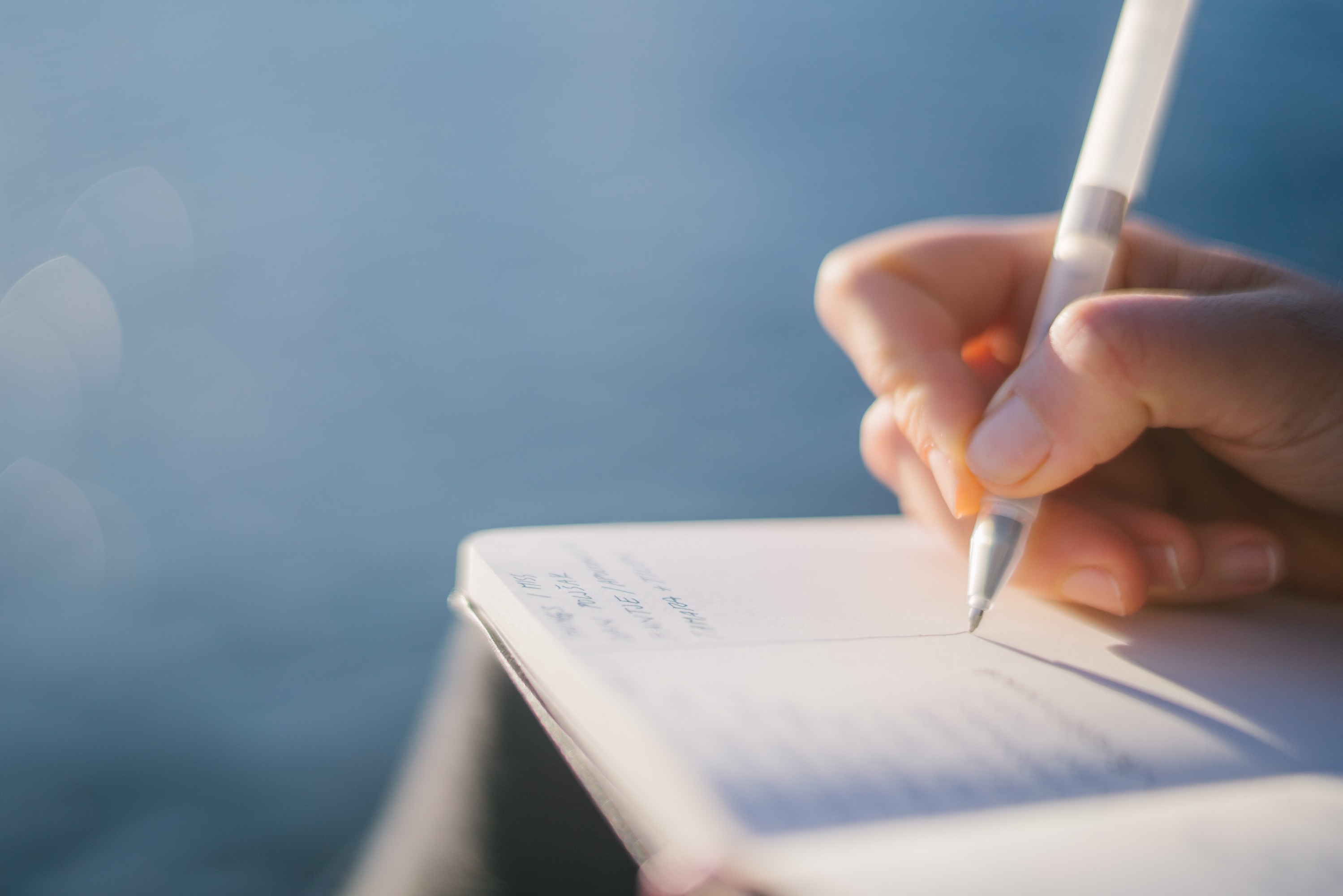 Hand writing in book with pen
