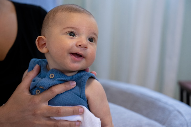 Young baby being held by his mother.