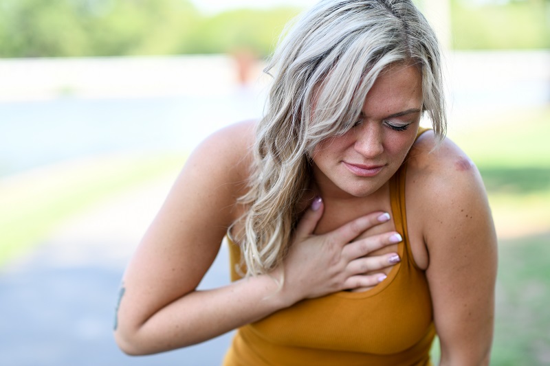 Woman clenches her chest in pain