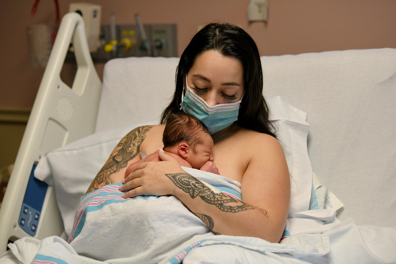 Mother holding her newborn baby on her chest.