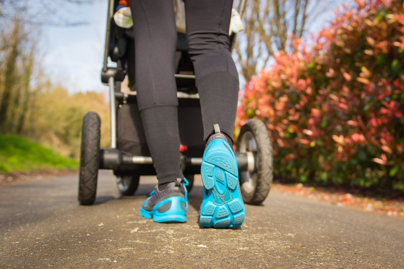 New mom walking with her baby in a stroller