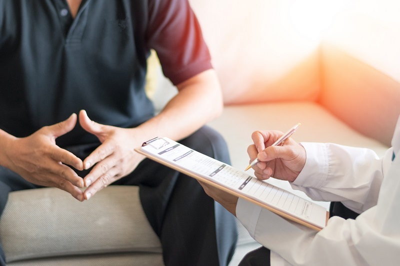 Doctor giving consult to a patient, discussing testicular lumps and cancer.