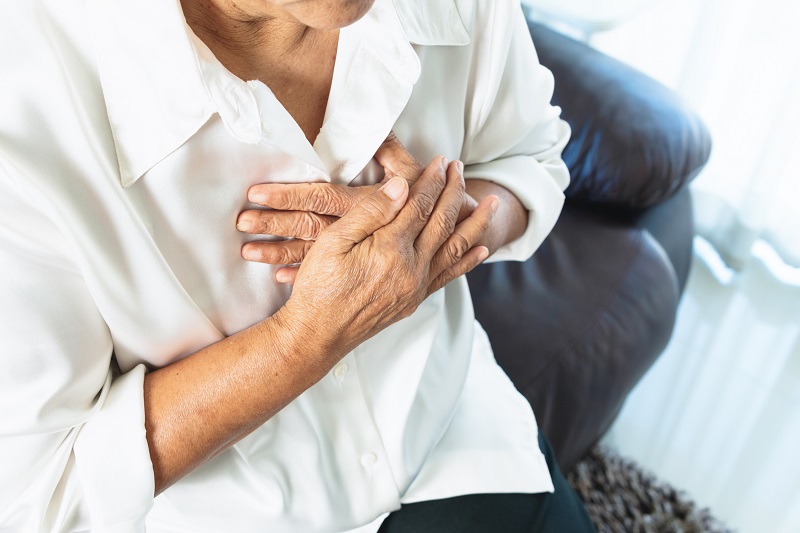 Woman holding her chest with difficulty breathing.