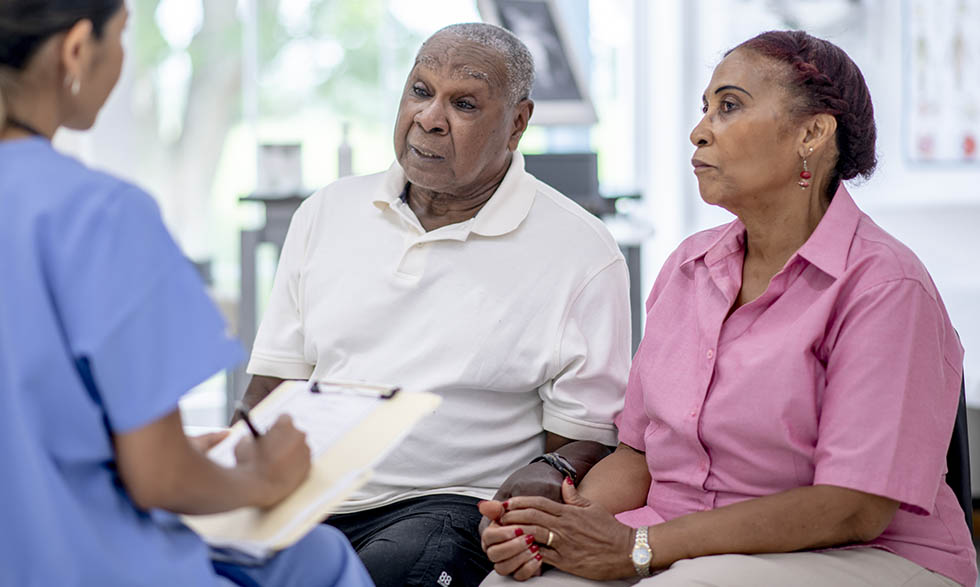 Man and woman speaking with nurse