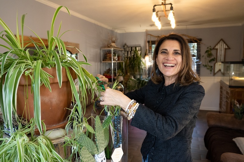 Maritza smiling and tending to her plants.