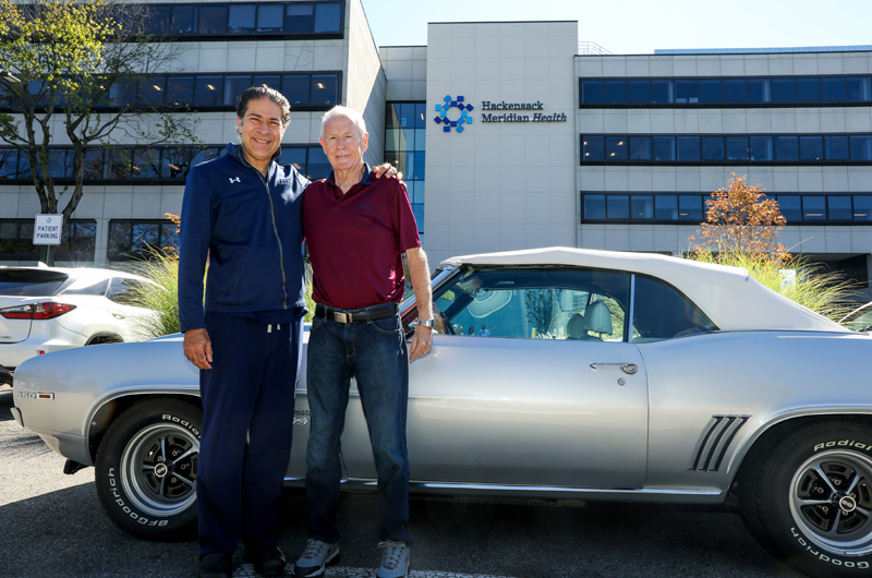 Dan Cooney outside hospital in front of Camarro