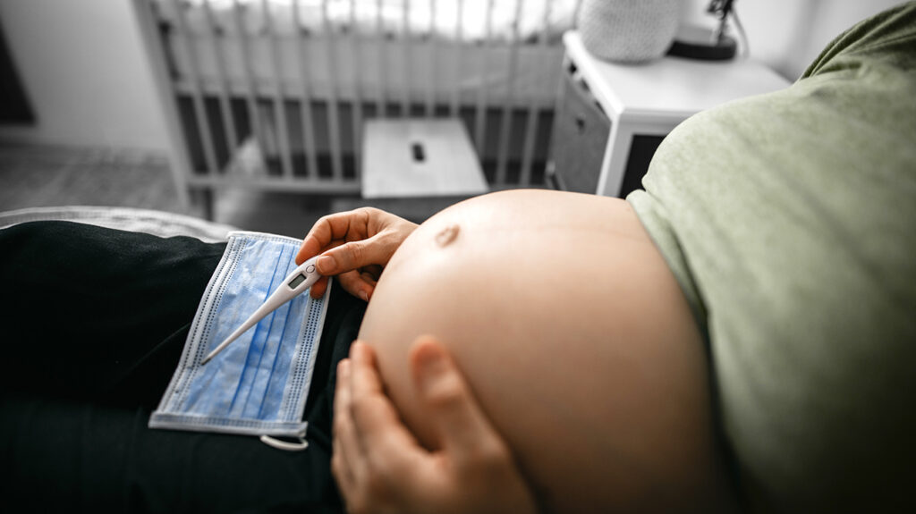 Pregnant woman with thermometer