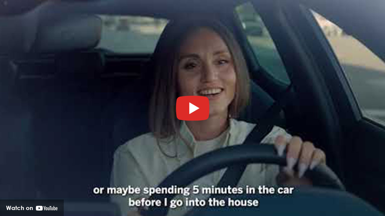 Woman sitting in car practicing stress relief before entering home