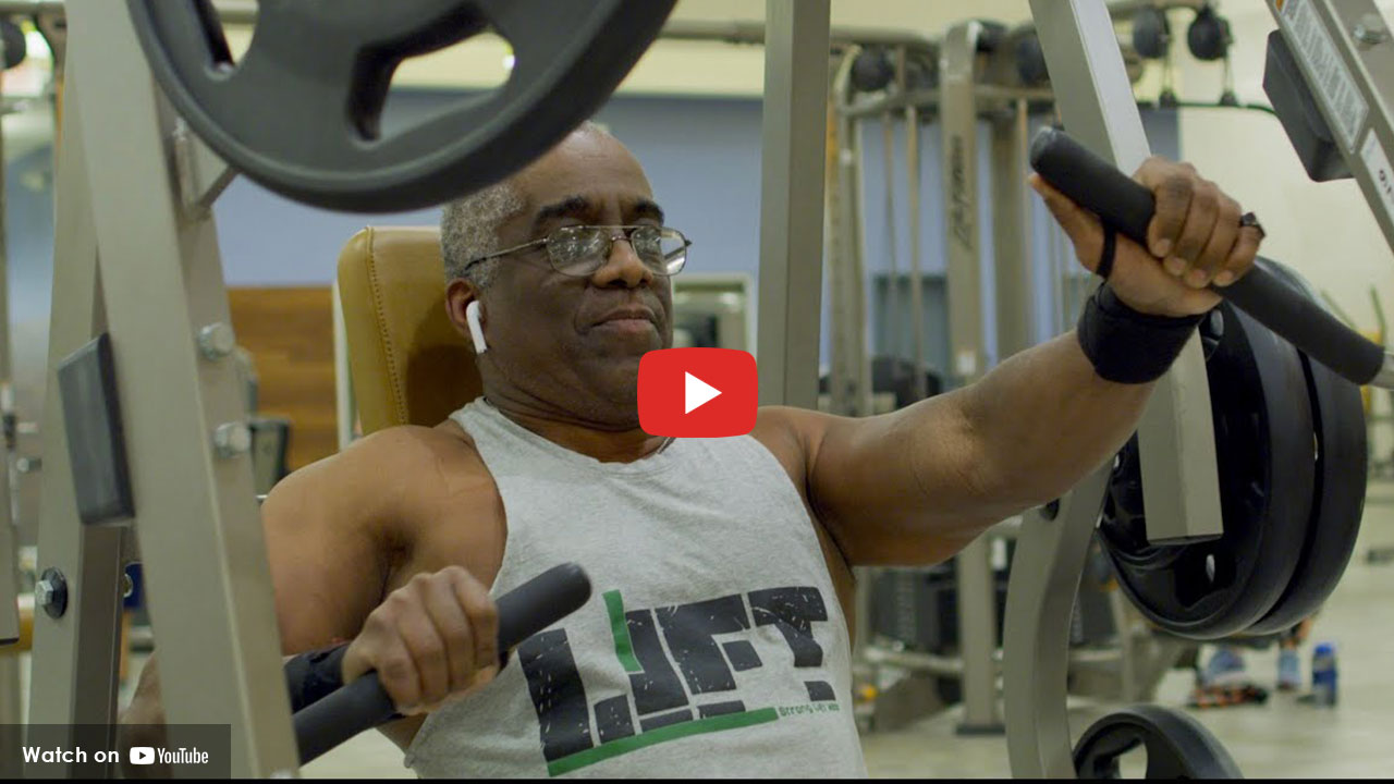 A man working out at the gym by using the weights.