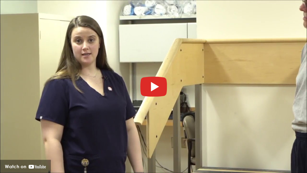 Woman in scrubs in rehab gym